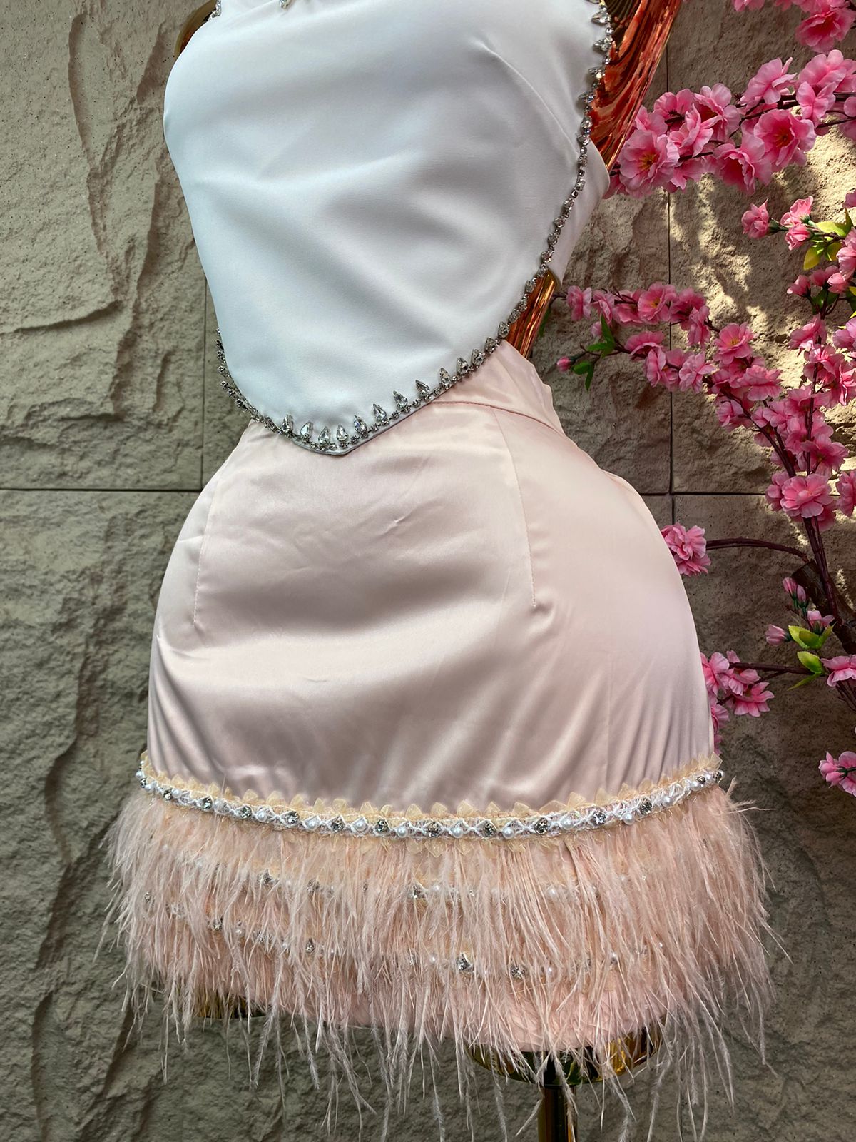 FALDA CORTA CON BROQUELES, PERLAS Y PLUMAS