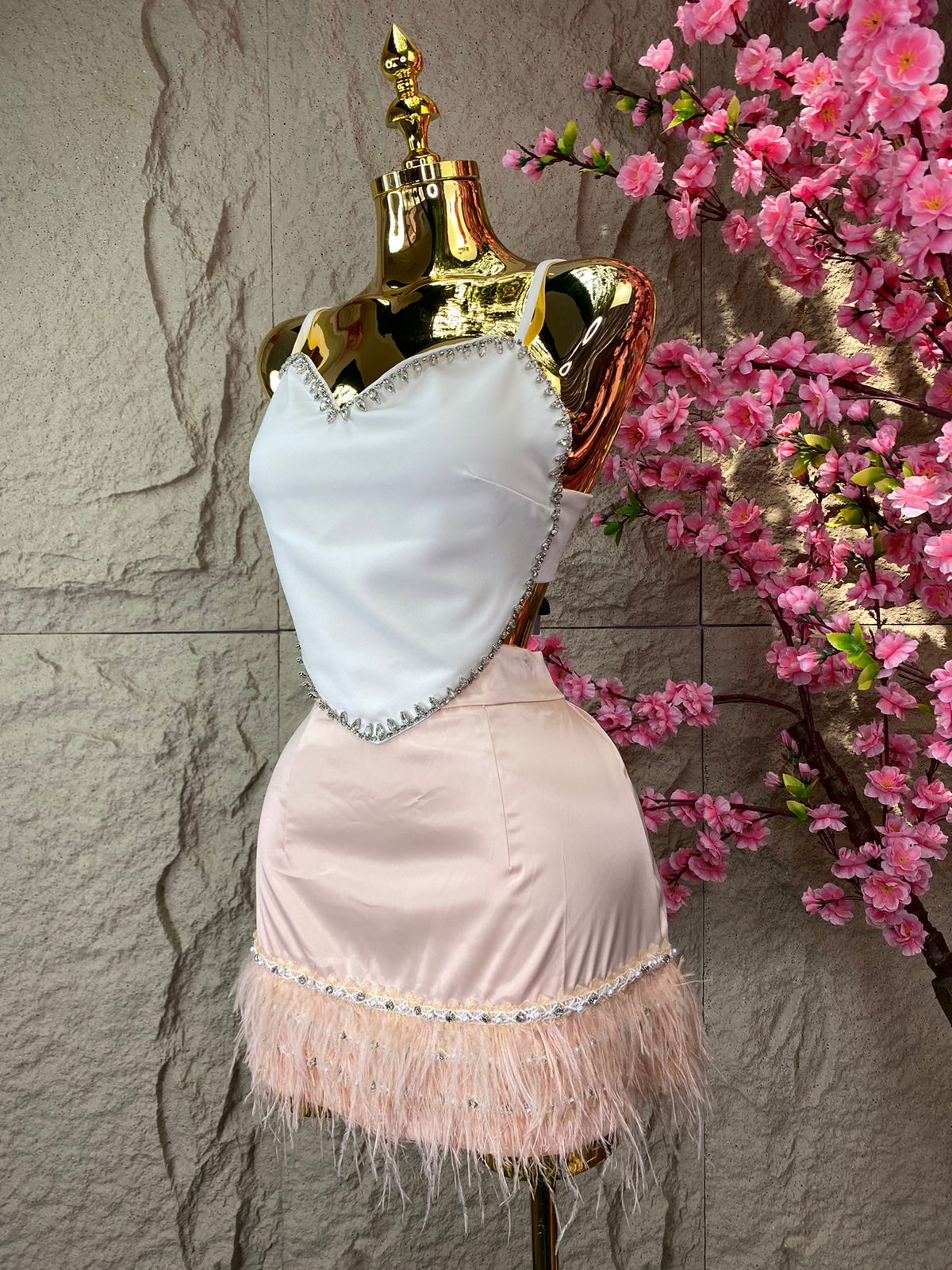 FALDA CORTA CON BROQUELES, PERLAS Y PLUMAS