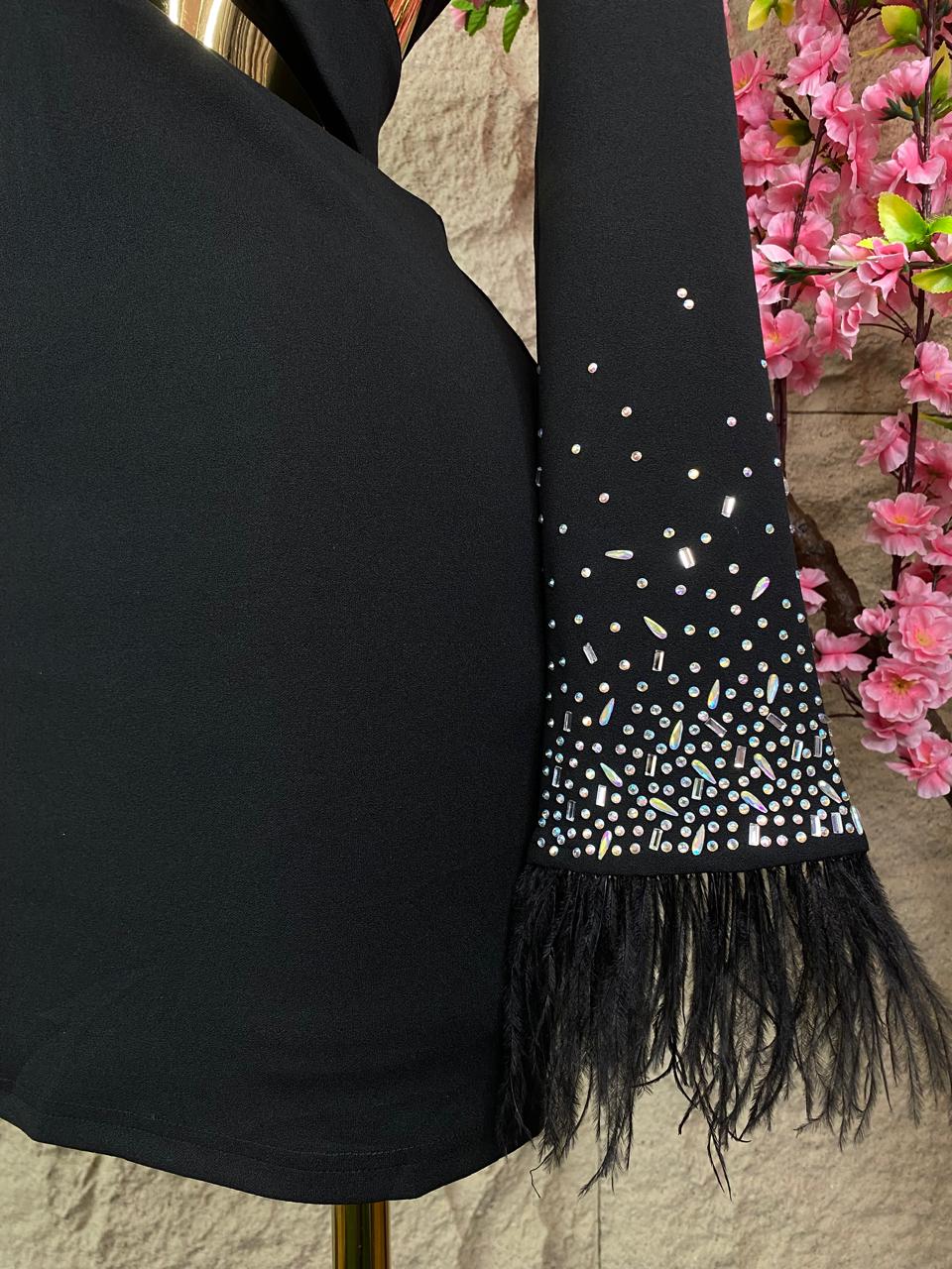 VESTIDO CON ESCOTE EN CADERA CON CRISTALES Y PLUMAS