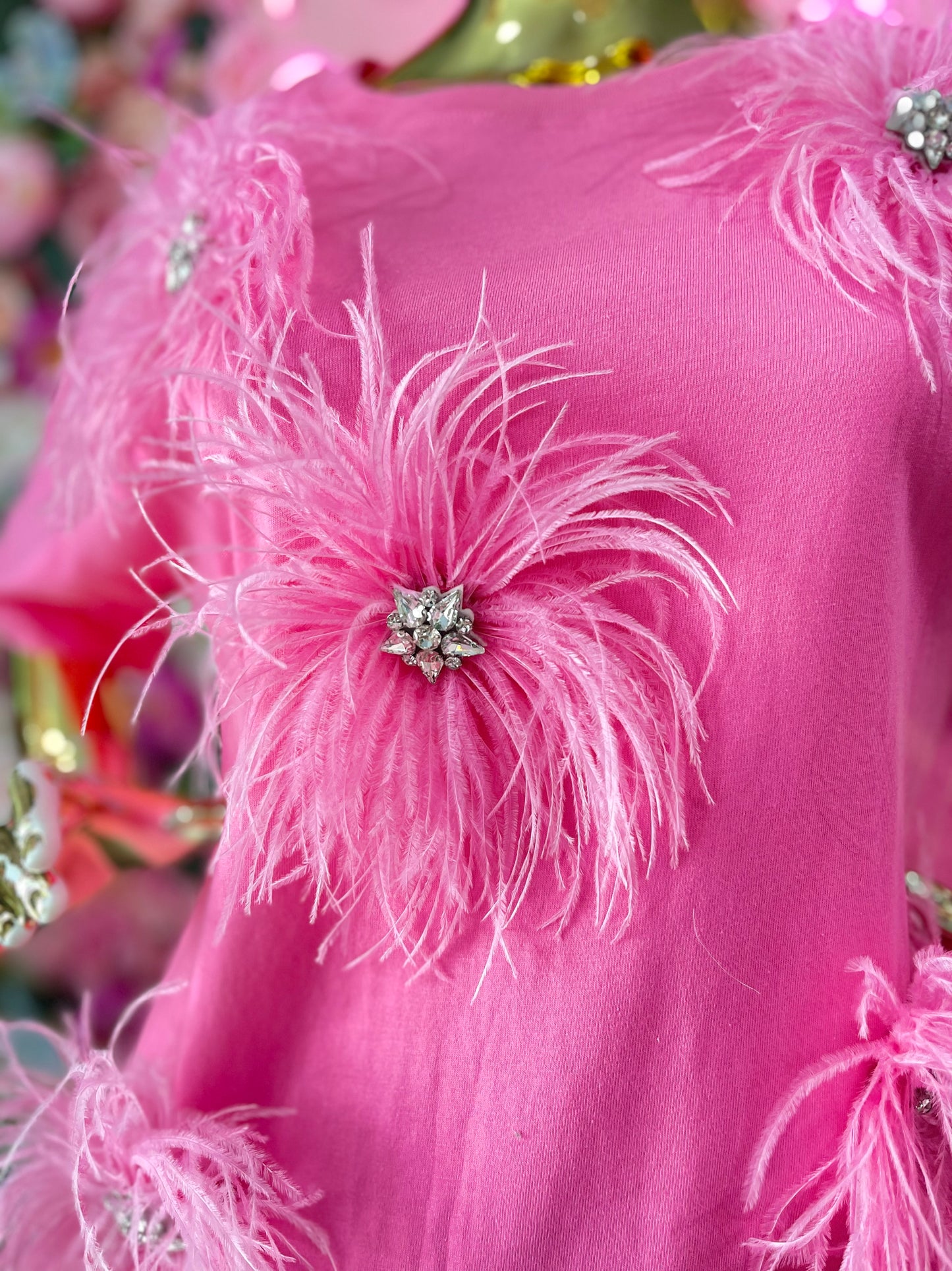 BLUSA CON PLUMAS Y BROQUELES ROSA